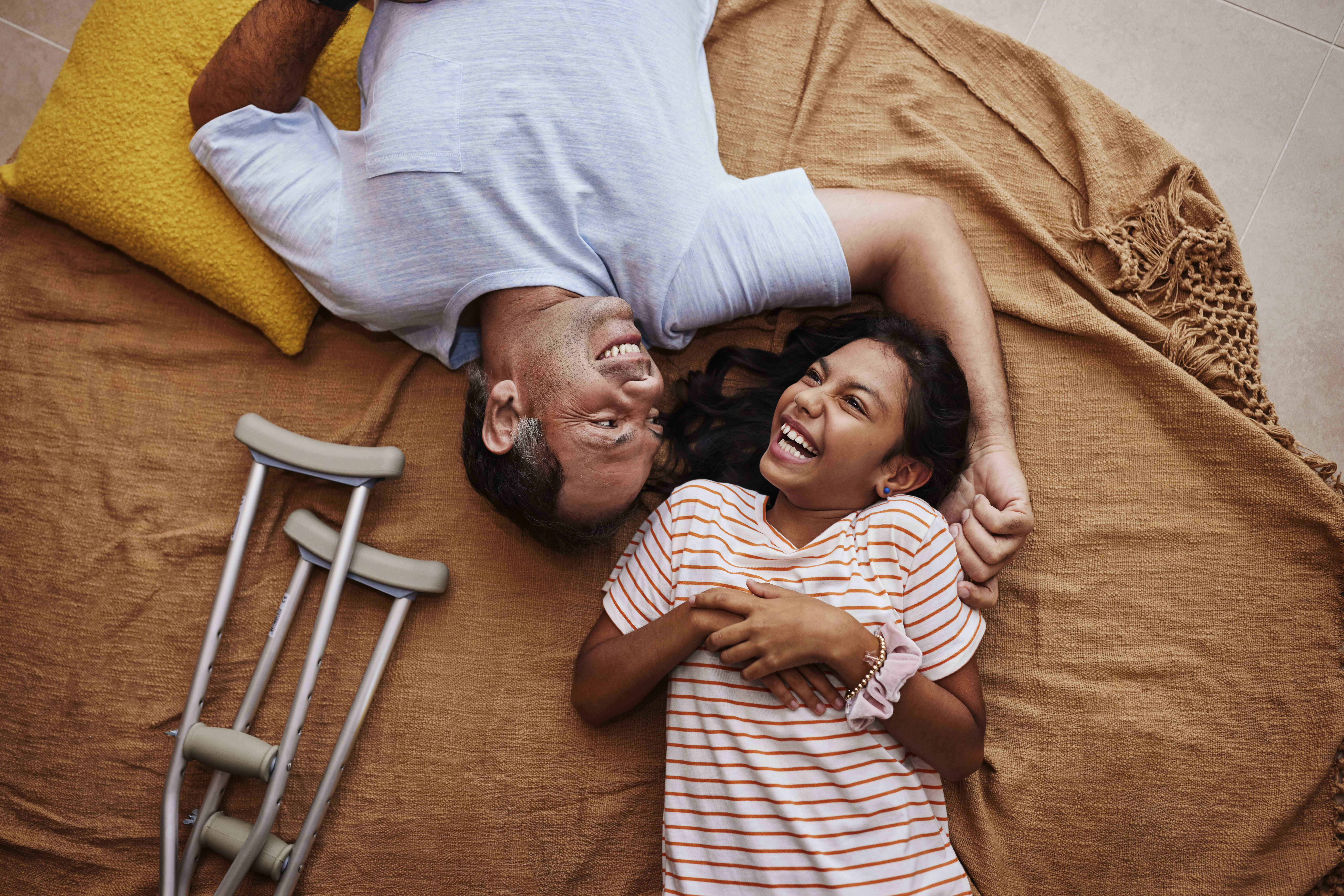 Man and daughter laughing while laying down